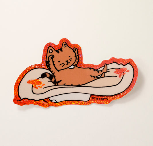 A drawing of a brown tabby cat, with its hands in the air, laying on a period pad and surrounded by blood that is glittery red