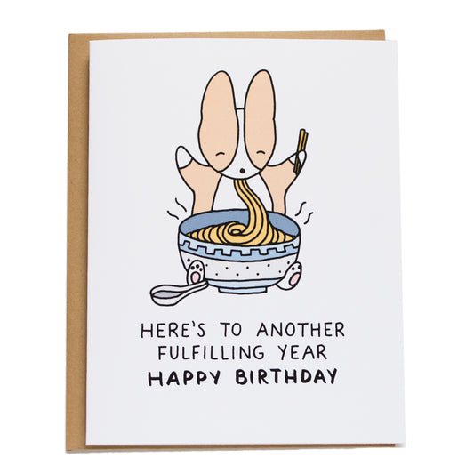 corgi eating a big bowl of noodles and card reads here's to another fulfilling year happy birthday