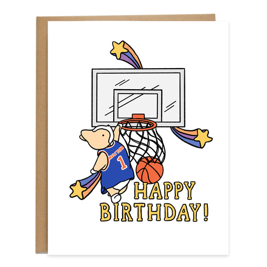 Drawing of a corgi in a NY Knicks jersey dunking at the basketball hoop. There are colorful shooting stars surrounding the hoop with the words, happy birthday, in yellow underneath
