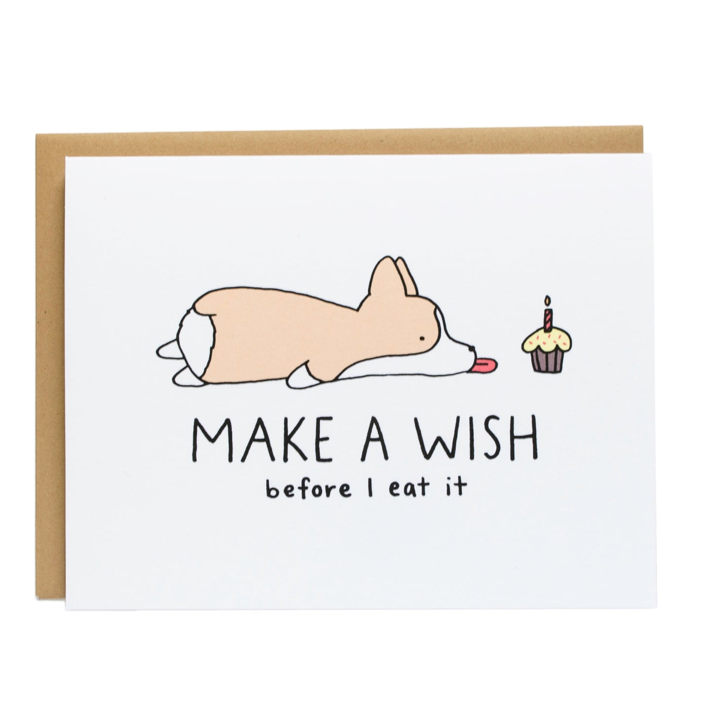 a corgi laying on its stomach with its tongue out next to a cupcake, the card reads, make a wish before i eat it