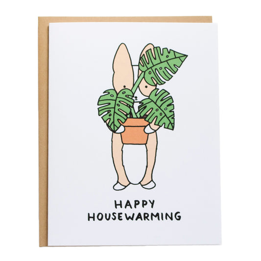 corgi holding monstera plant covering parts of his face, card reads, happy housewarming