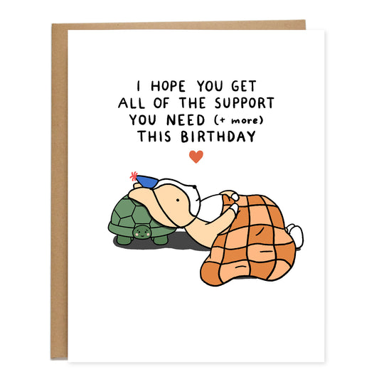 A drawing of a corgi laying down with a checkered blanket on the floor and turtle holding up his head like a pillow. Text reads, I hope you get all of the support you need (+ more) this birthday.