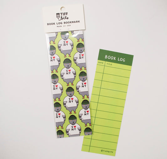 A green bookmark with a pattern design of a pigeon wearing a I Heart NY shirt and on the back is a book log design