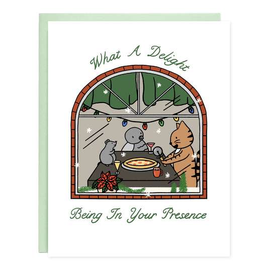 Card looking into a window with holidays lights of a rat, pigeon, and cat friends around a table drinking and eating a pizza pie. The card reads, What A Delight Being In Your Presence
