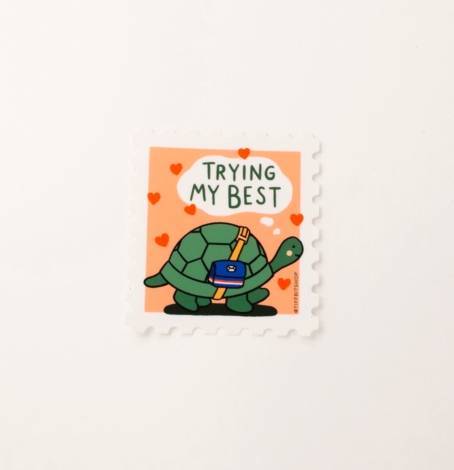 A sticker design mimicking a stamp shaped border with a drawing of a turtle delivering mail and it reads, trying my best