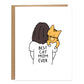 mom with mid length brunette hair with their back turned is holding a orange cat on their shoulder, the back of the shirt reads best cat mom ever