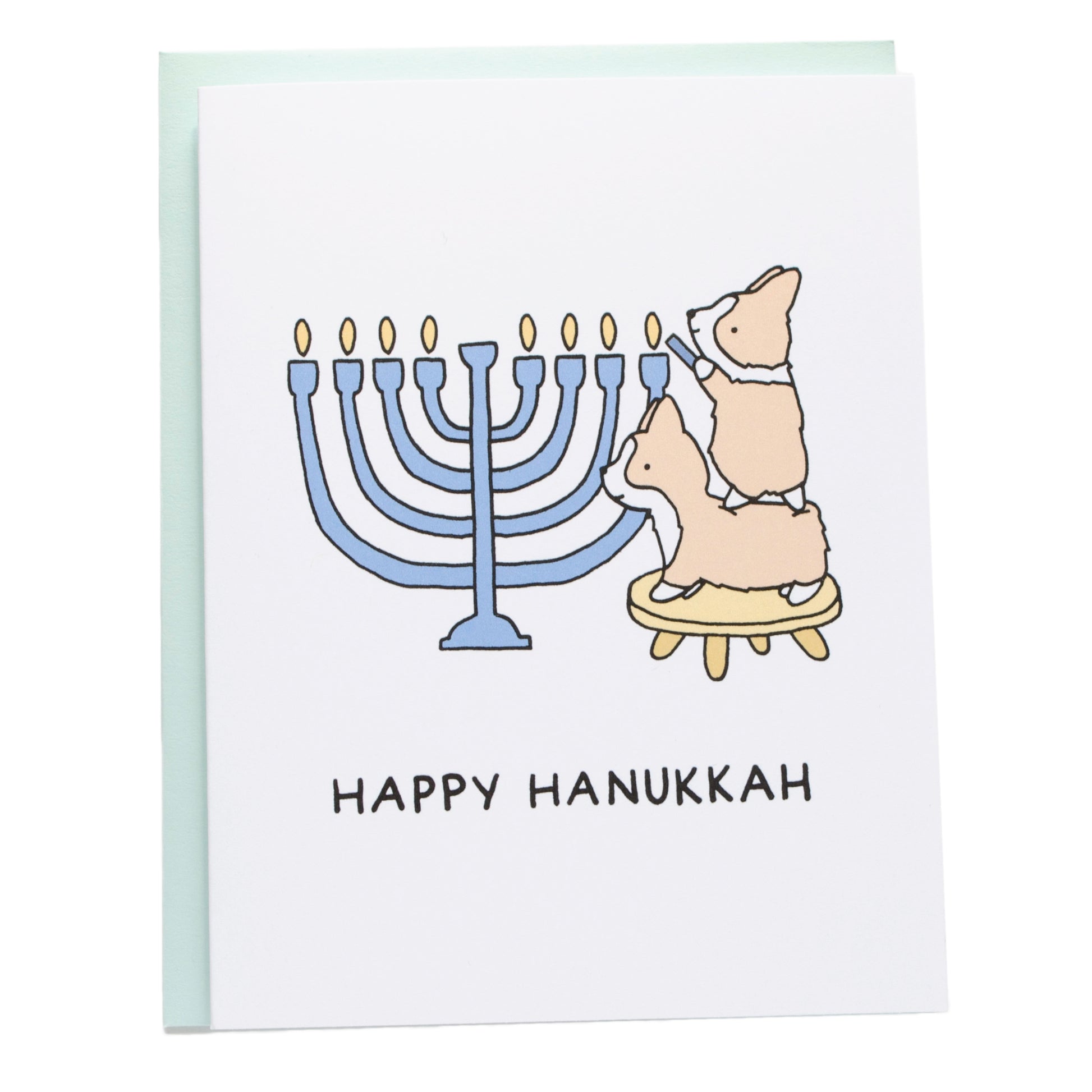 two corgis on a stool lighting a large blue menorah, card reads, happy hanukkah