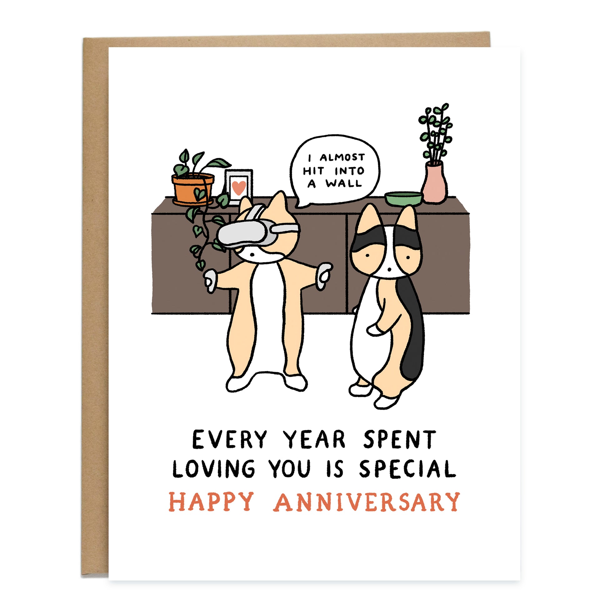 A drawing of two corgis at home, one is wearing a VR headset with their arms out, a speech bubble above them reads, I almost hit into a wall. Another corgi stares straight ahead. The card reads, every year spent loving you is special, happy anniversary.